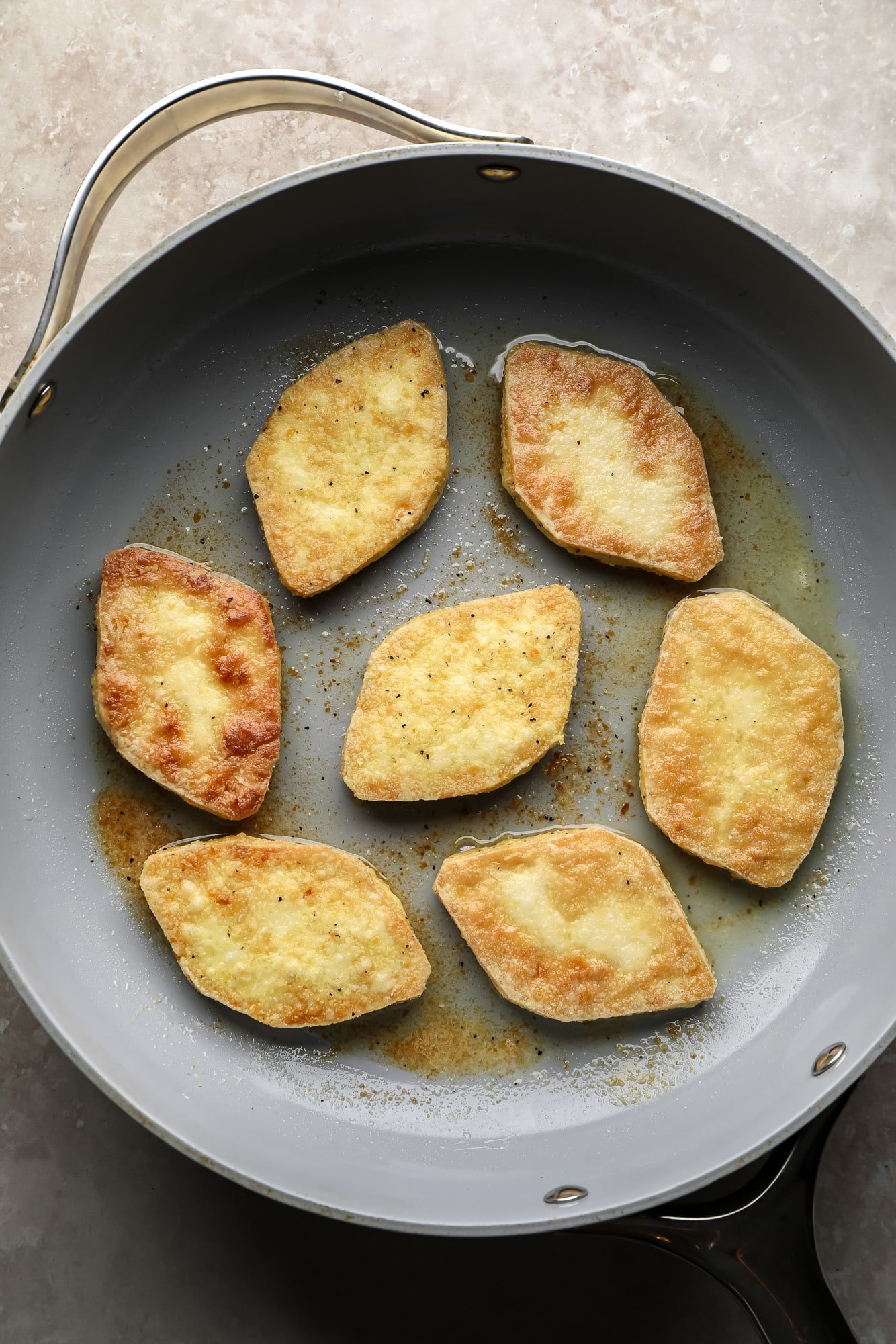 Fritando pedaços de tofu em uma frigideira grande.